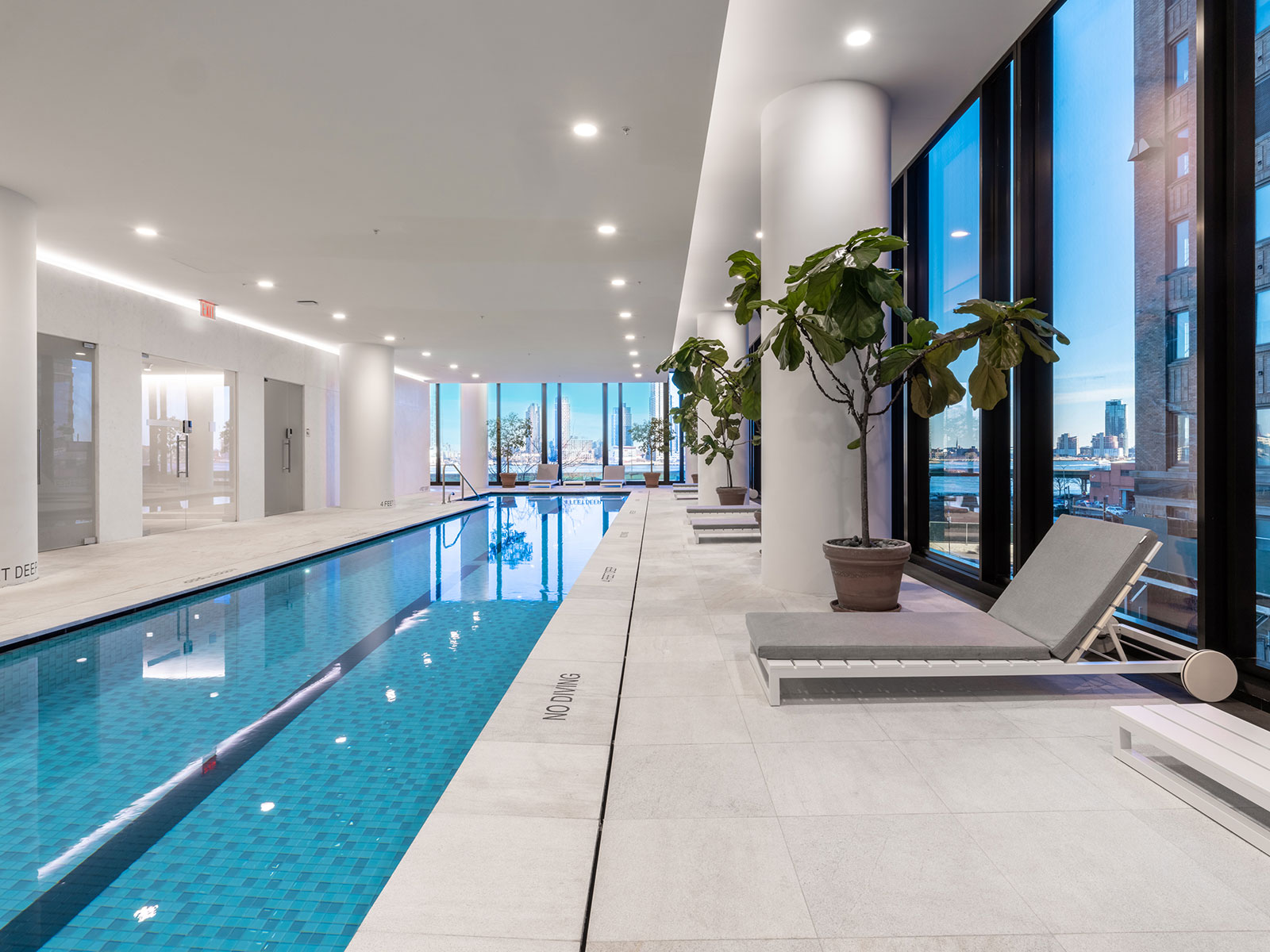 Beautiful, luxury indoor pool with lounge seating and elegant design at 685 First Avenue, apartments for rent in Murray Hill.
